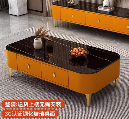 Modern rectangular coffee table featuring a white faux-marble tabletop, orange upholstered storage drawers, and gold legs