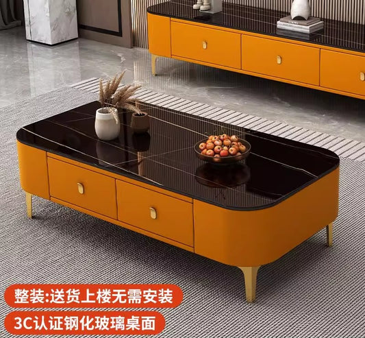 Modern rectangular coffee table featuring a white faux-marble tabletop, orange upholstered storage drawers, and gold legs